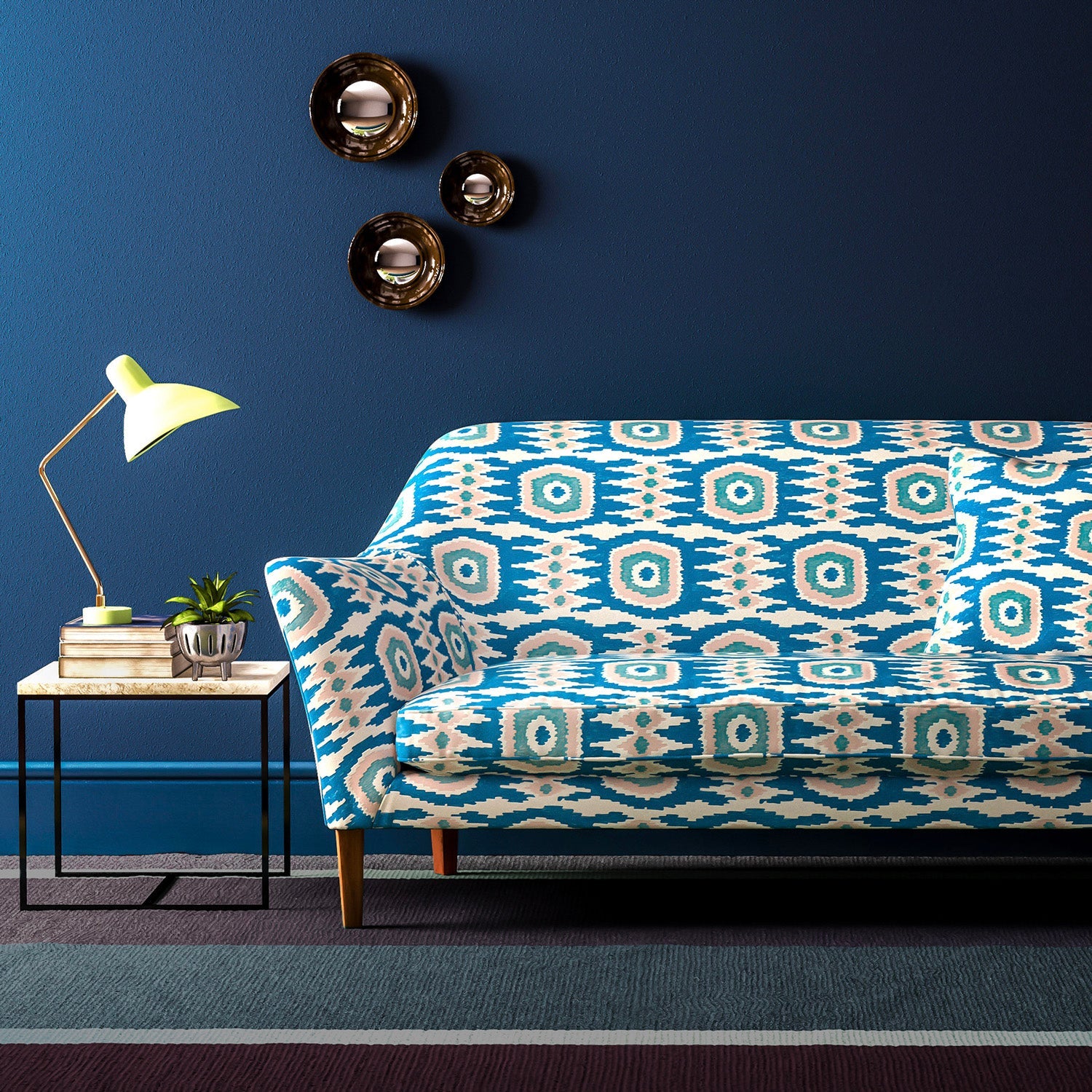 Sofa covered in a printed velvet upholstery fabric featuring a fun, jazzy pattern in blue, green and pink.