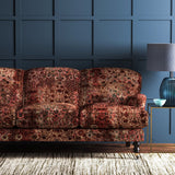 Sofa covered in a velvet upholstery fabric with  an antique carpet-style design.