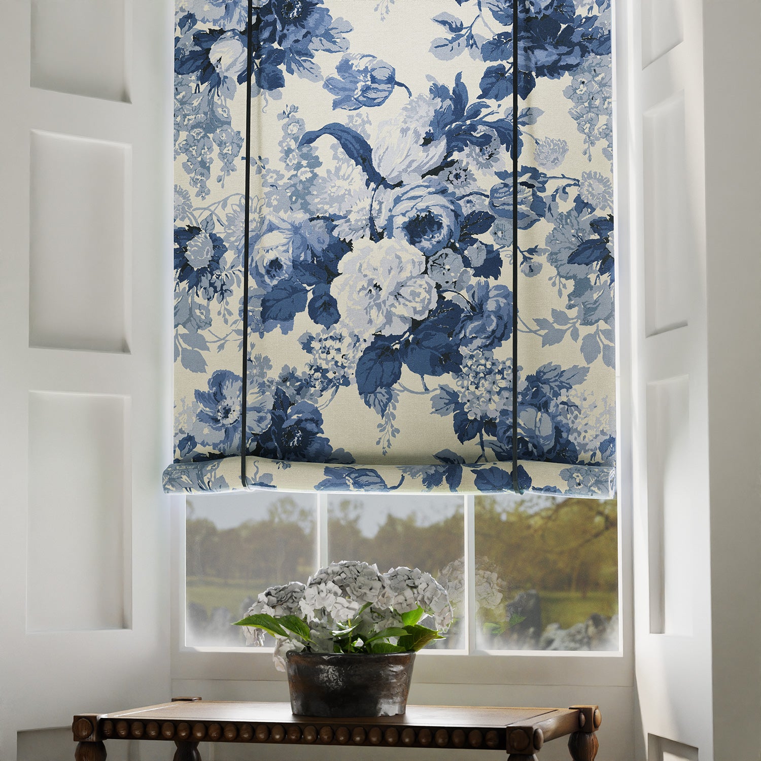 Blind in a printed linen fabric with bouquets of roses in blue and white colours.