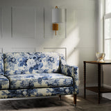 Sofa in a printed linen fabric with bouquets of roses in blue and white colours.