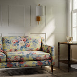 Sofa in a printed linen fabric with bouquets of roses on a yellow background.