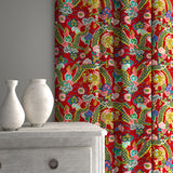 Velvet curtains upholstered in a printed velvet fabric with a intricate mirror dragon design in red colours.