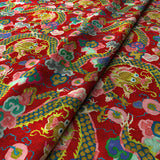 Printed velvet fabric with intricate mirror dragon design in red colours, for upholstery and curtain use.