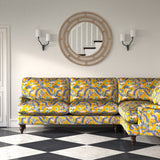 Velvet sofa upholstered in a printed velvet fabric with a intricate mirror dragon design in yellow colours.