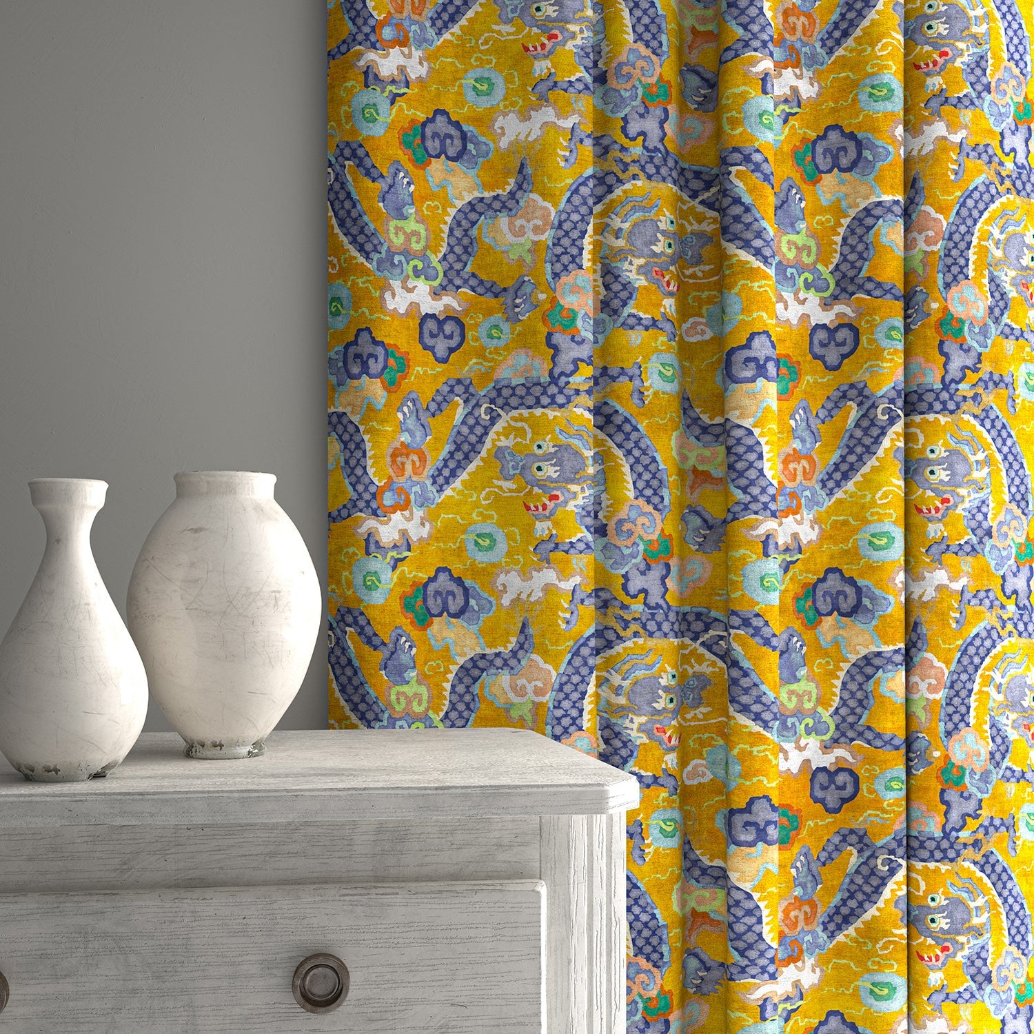 Velvet curtains upholstered in a printed velvet fabric with a intricate mirror dragon design in yellow colours.