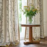 Curtains made from a printed linen fabric with grey and white stripes and an oak-leaf motif.