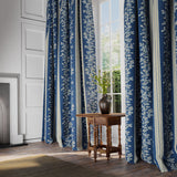 Curtains in a printed linen fabric with blue and white stripes and an oak-leaf motif.