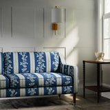 Sofa covered in a printed linen fabric with blue and white stripes and an oak-leaf motif.