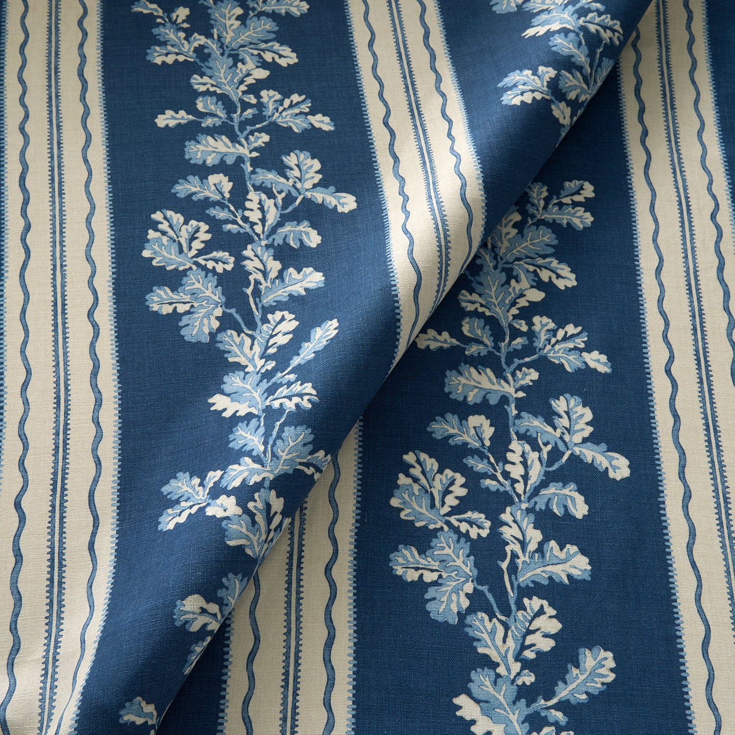 Printed linen fabric with blue and white stripes and an oak-leaf motif.