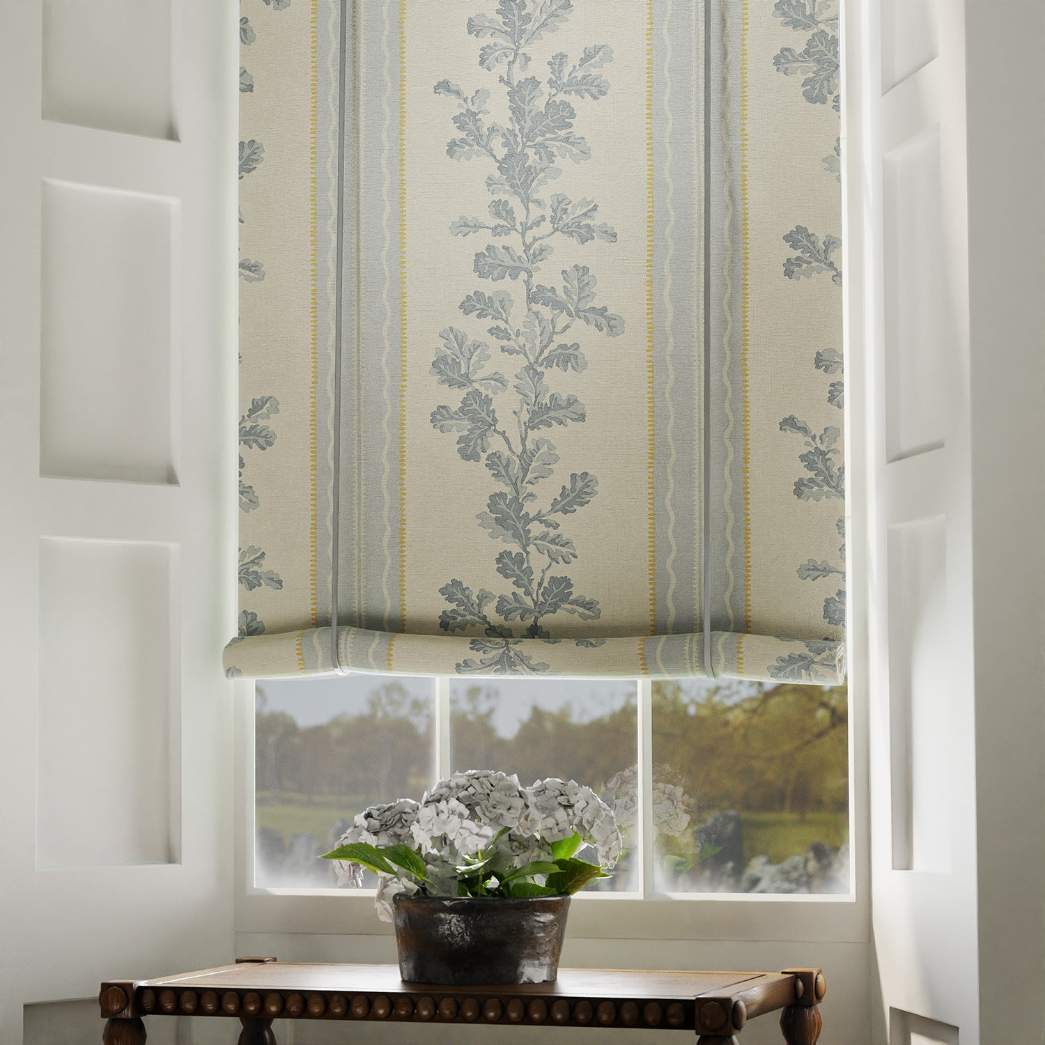 Blind in a printed linen fabric with grey and white stripes and an oak-leaf motif.