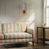Sofa in a printed linen fabric with pink and green stripes and an oak-leaf motif.