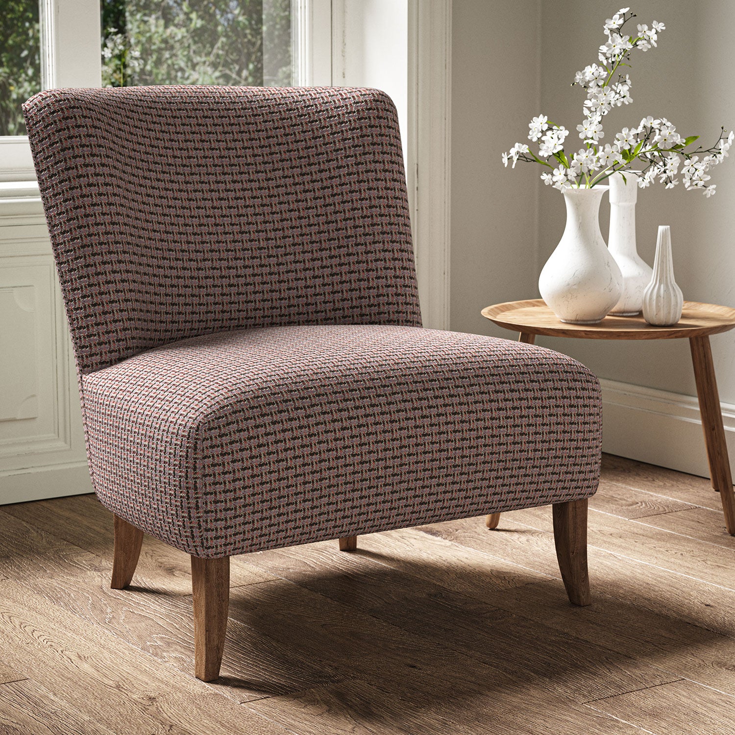 Armchair in a printed linen fabric with textural weave pattern in pink and black colours.