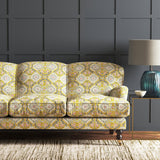 Velvet sofa upholstered in a printed velvet fabric with an oriental geometric design in yellow colours