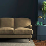 Sofa covered in a brown velvet upholstery fabric