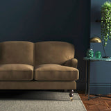 Sofa covered in a brown velvet upholstery fabric