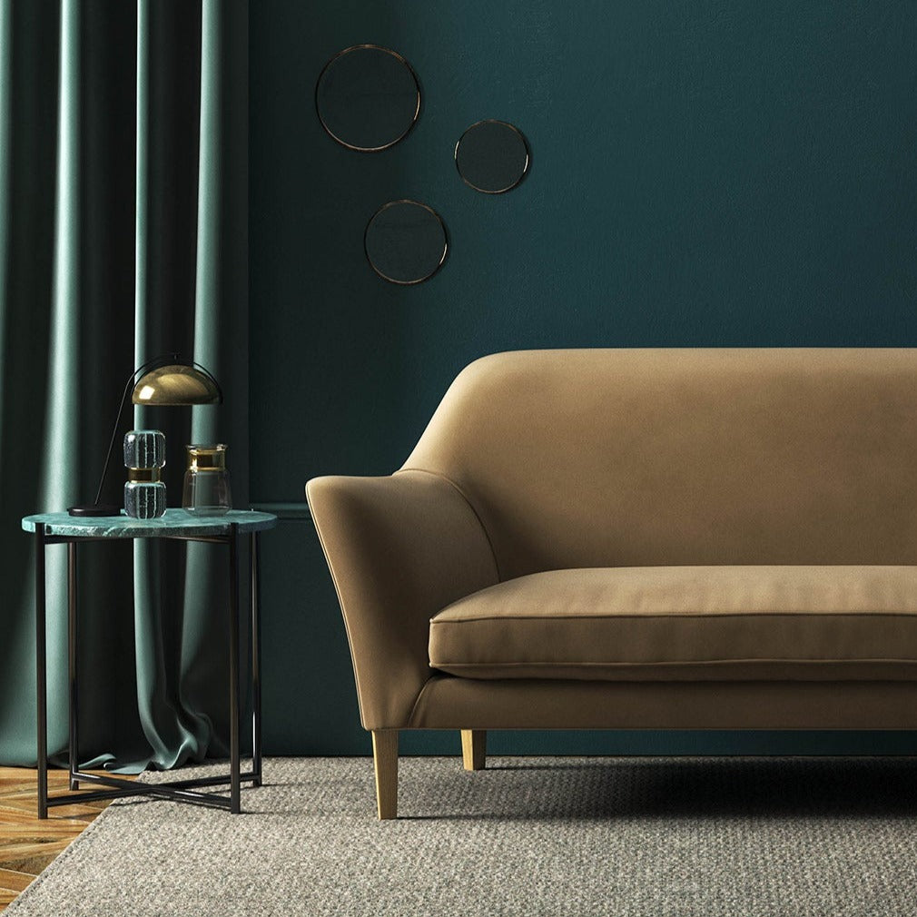 Sofa covered in a brown velvet upholstery fabric 