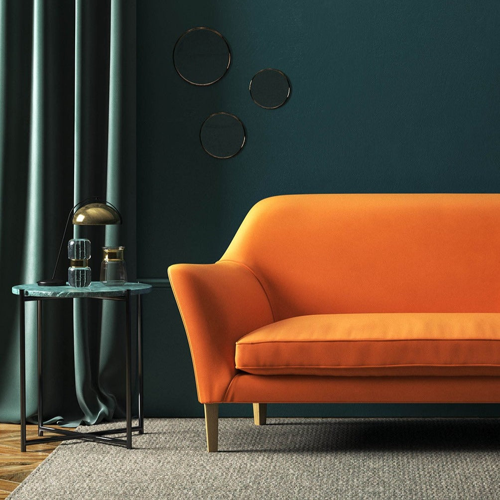 Sofa covered in a orange velvet upholstery fabric 