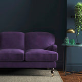 Sofa covered in a purple velvet upholstery fabric 