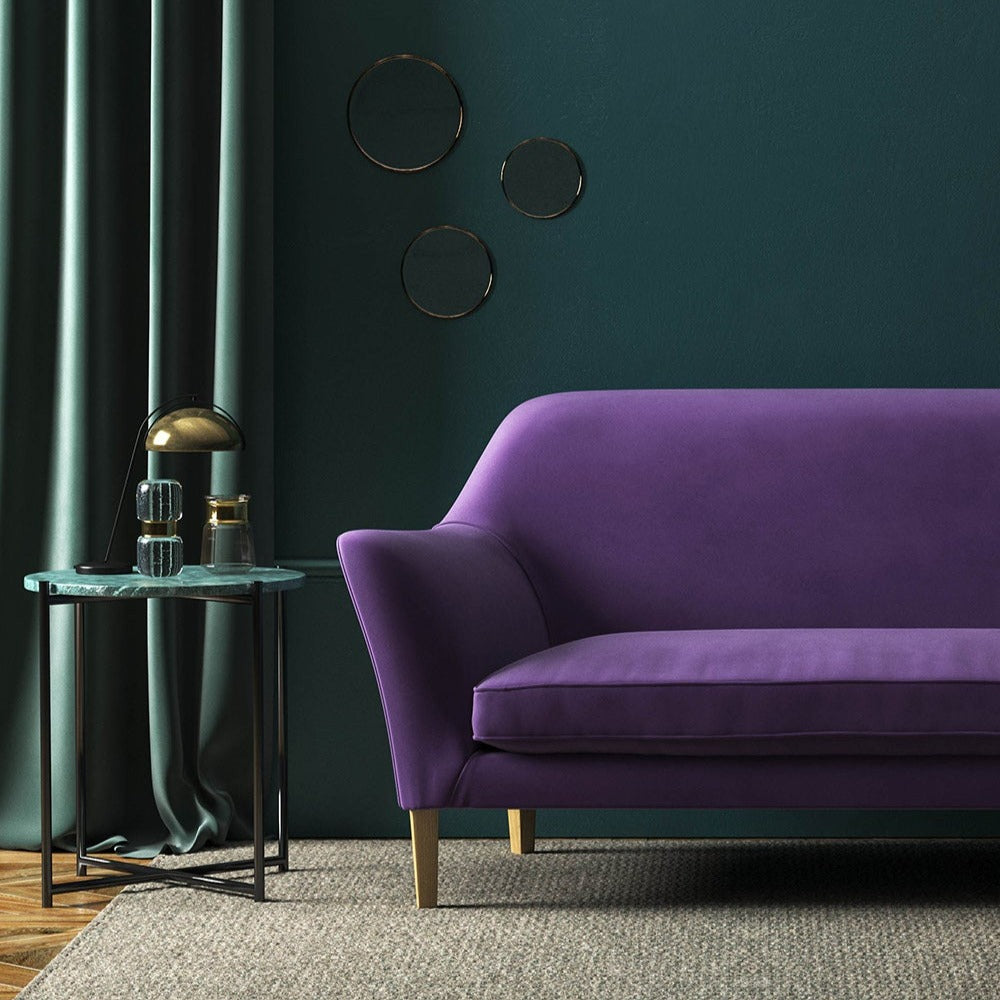 Sofa covered in a purple velvet upholstery fabric 