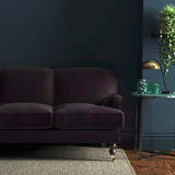 Sofa covered in a purple velvet upholstery fabric