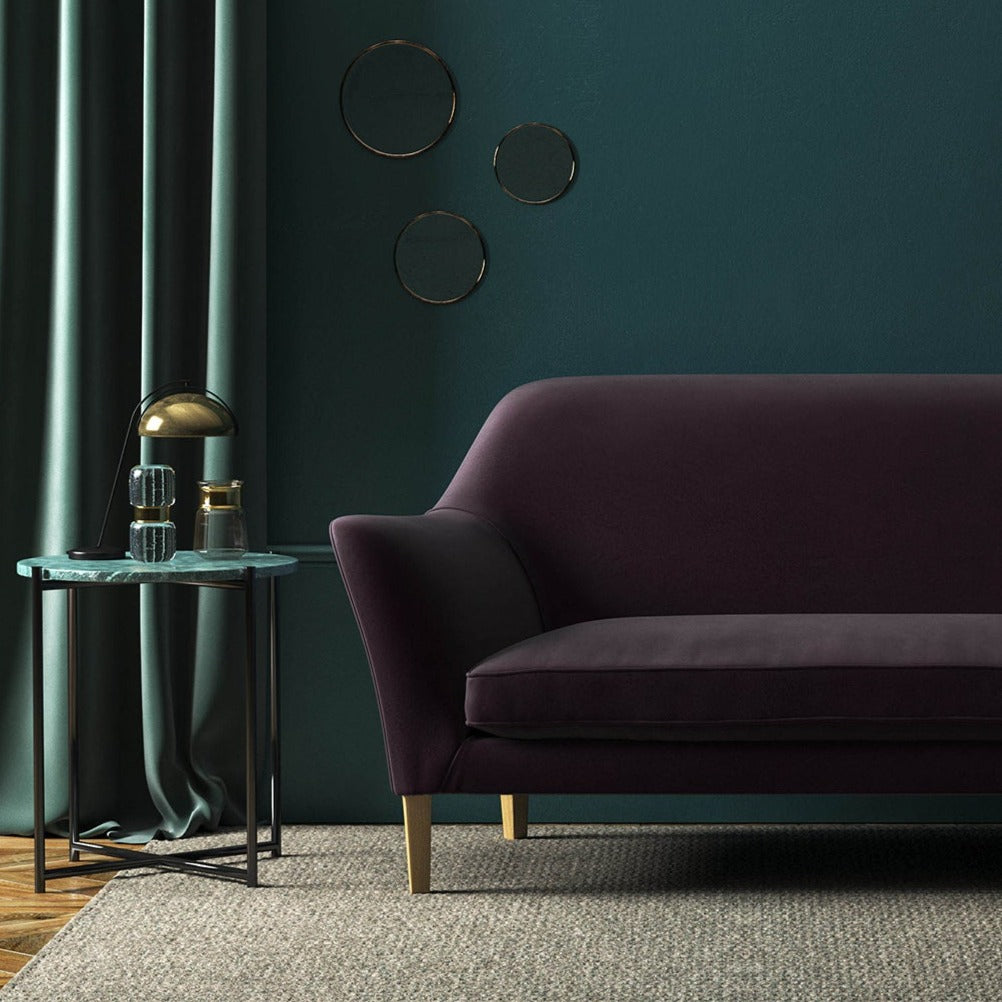 Sofa covered in a purple velvet upholstery fabric 