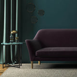 Sofa covered in a purple velvet upholstery fabric 