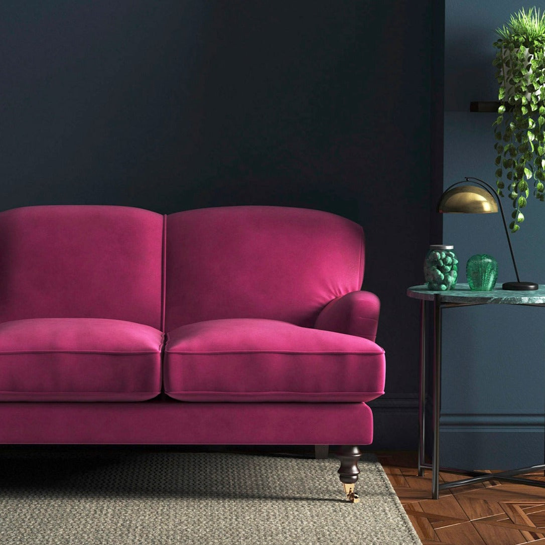 Sofa covered in a pink velvet upholstery fabric