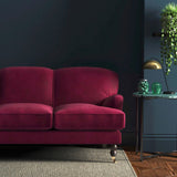 Sofa covered in a pink velvet upholstery fabric
