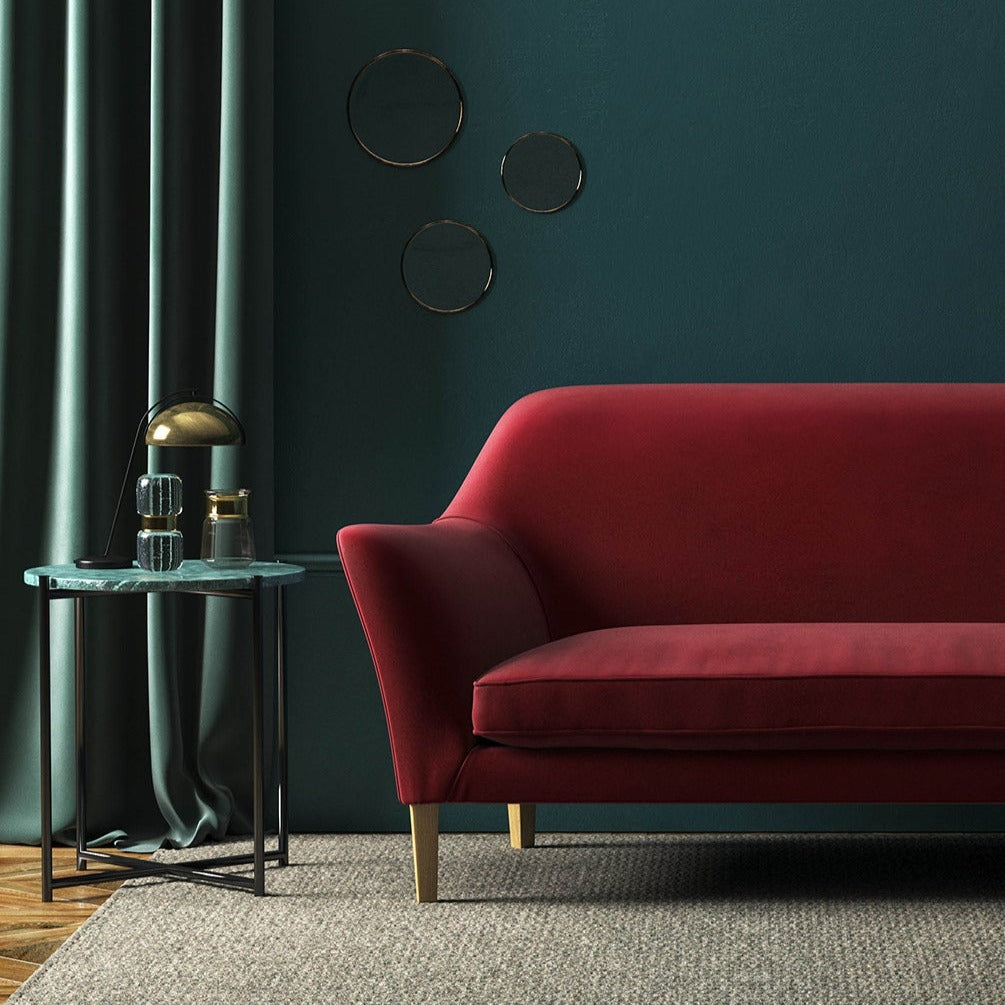 Sofa covered in a red velvet upholstery fabric 