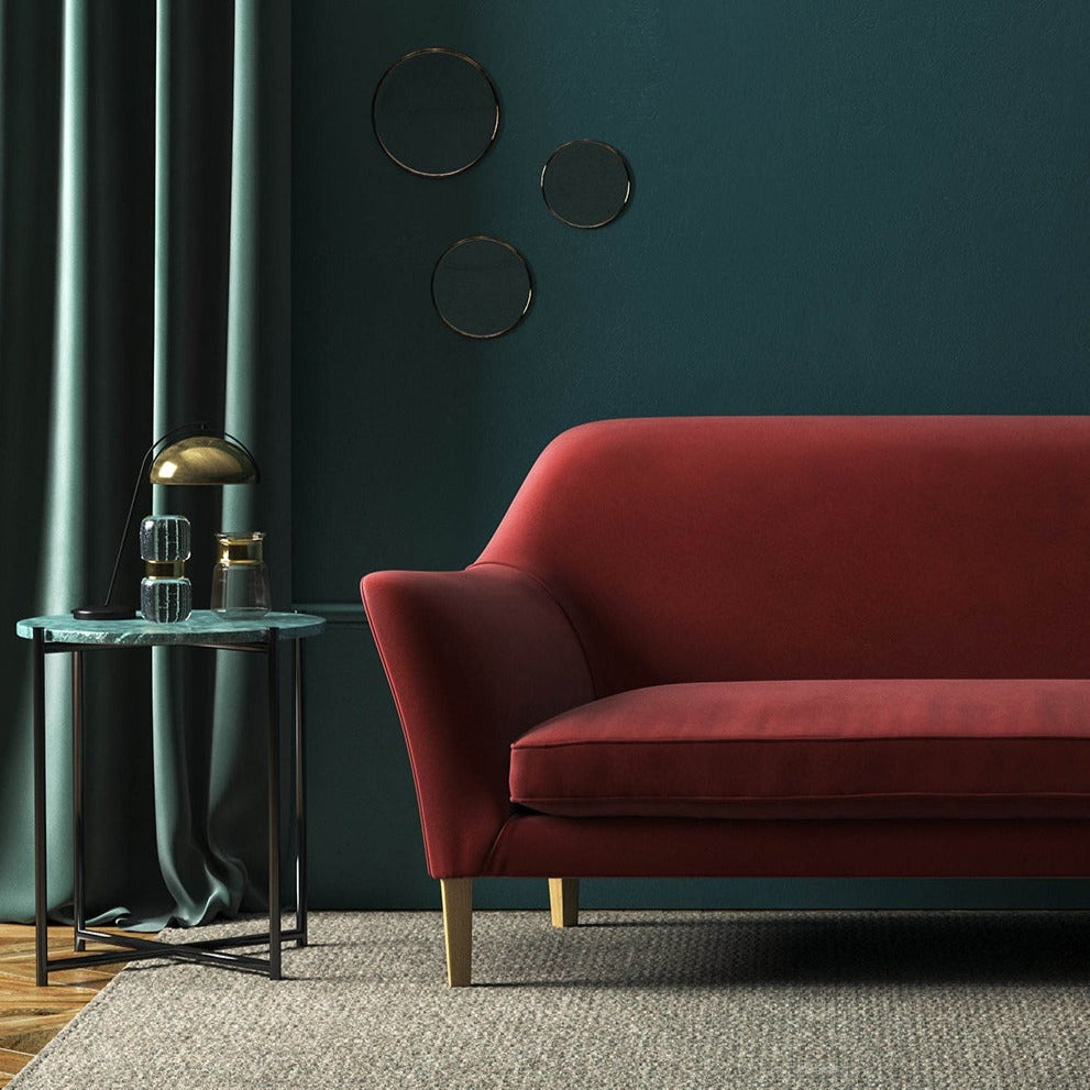 Sofa covered in a red velvet upholstery fabric 