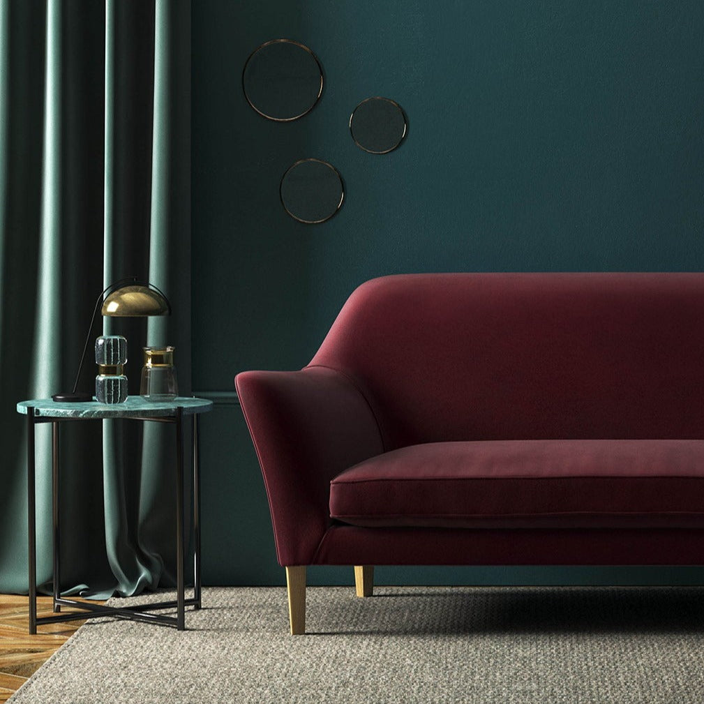 Sofa covered in a red velvet upholstery fabric 