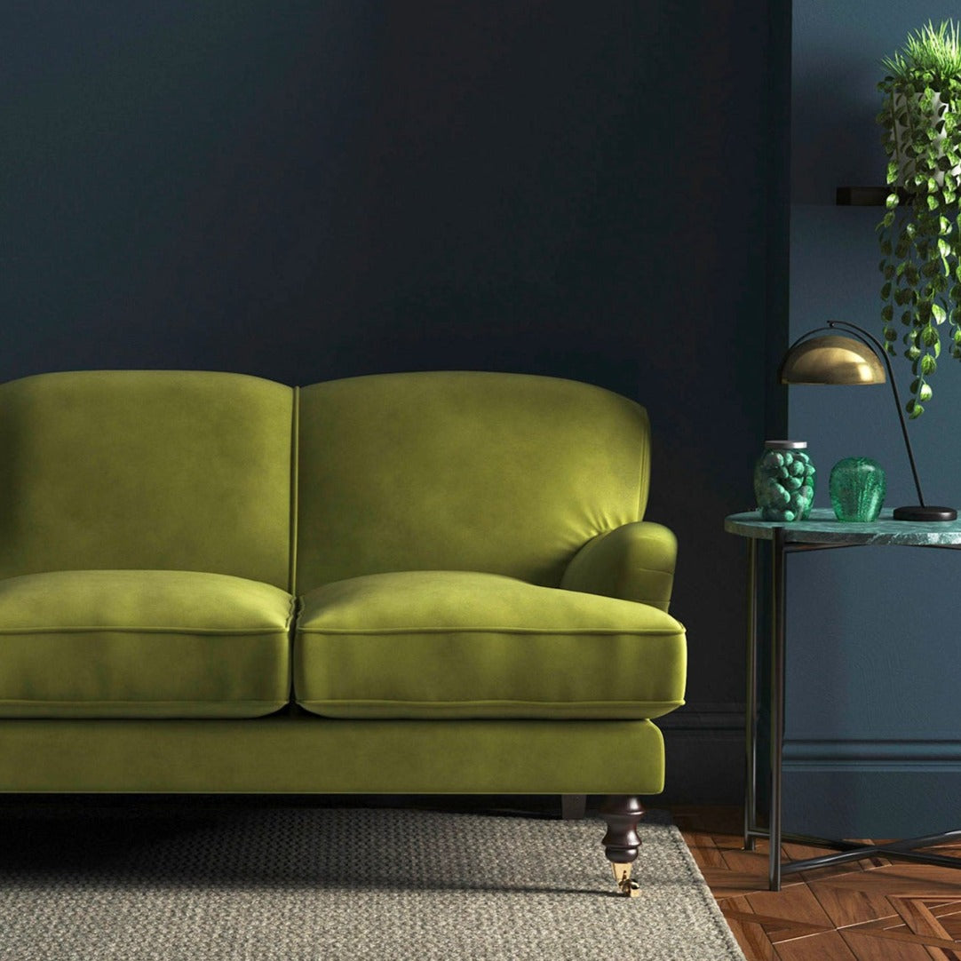 Sofa covered in a green velvet upholstery fabric