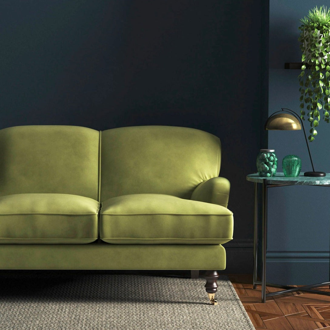 Sofa covered in a green velvet upholstery fabric