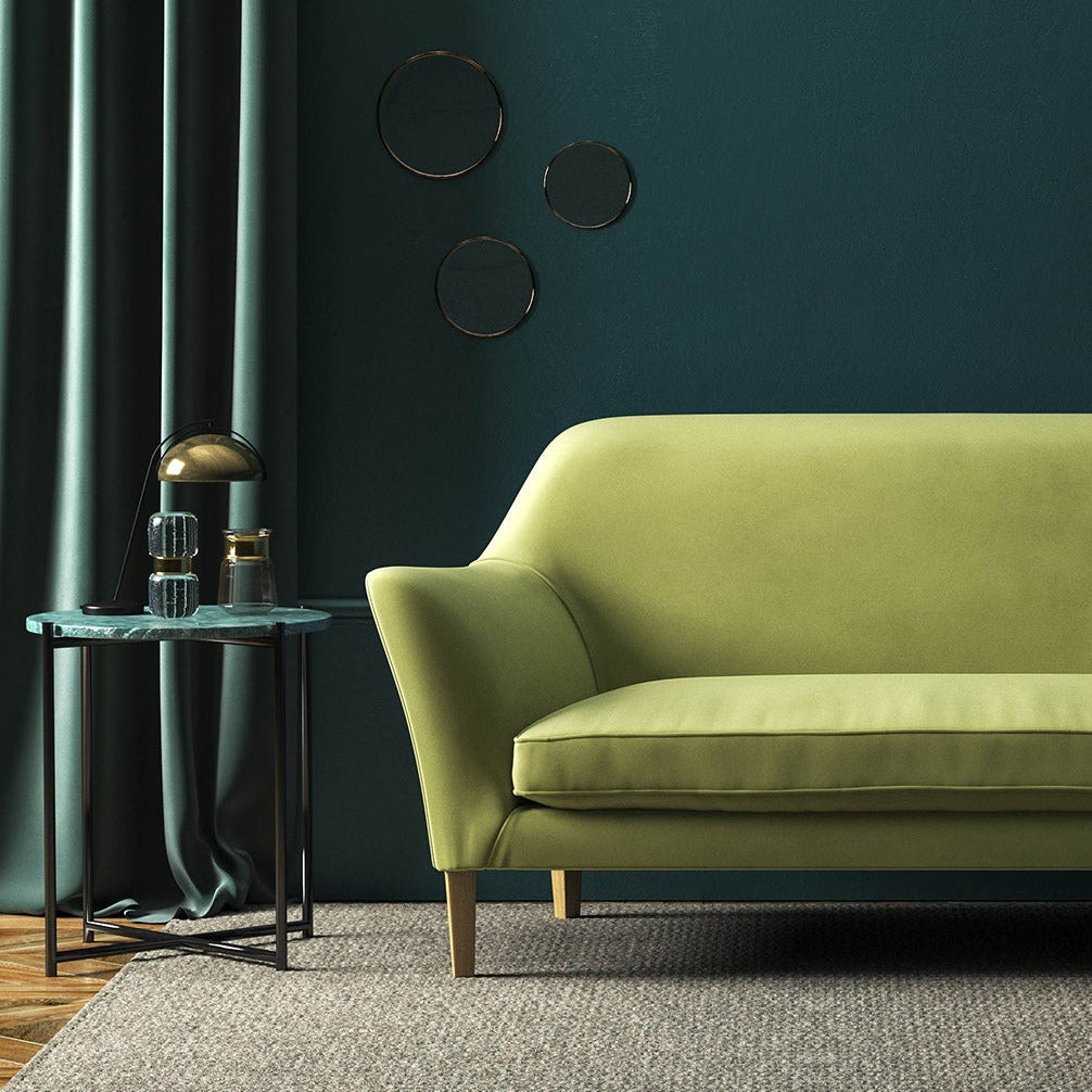 Sofa covered in a green velvet upholstery fabric 