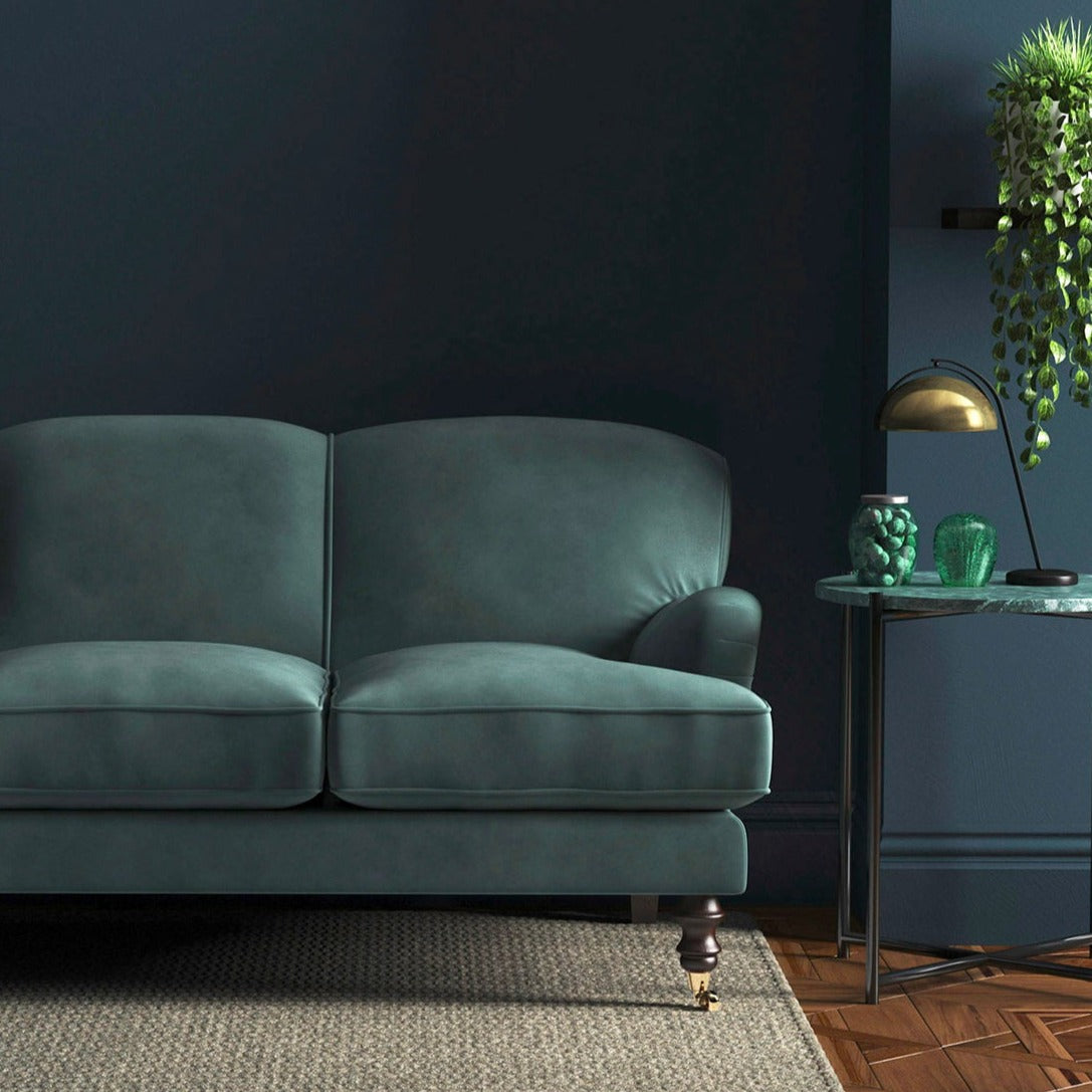 Sofa covered in a blue velvet upholstery fabric