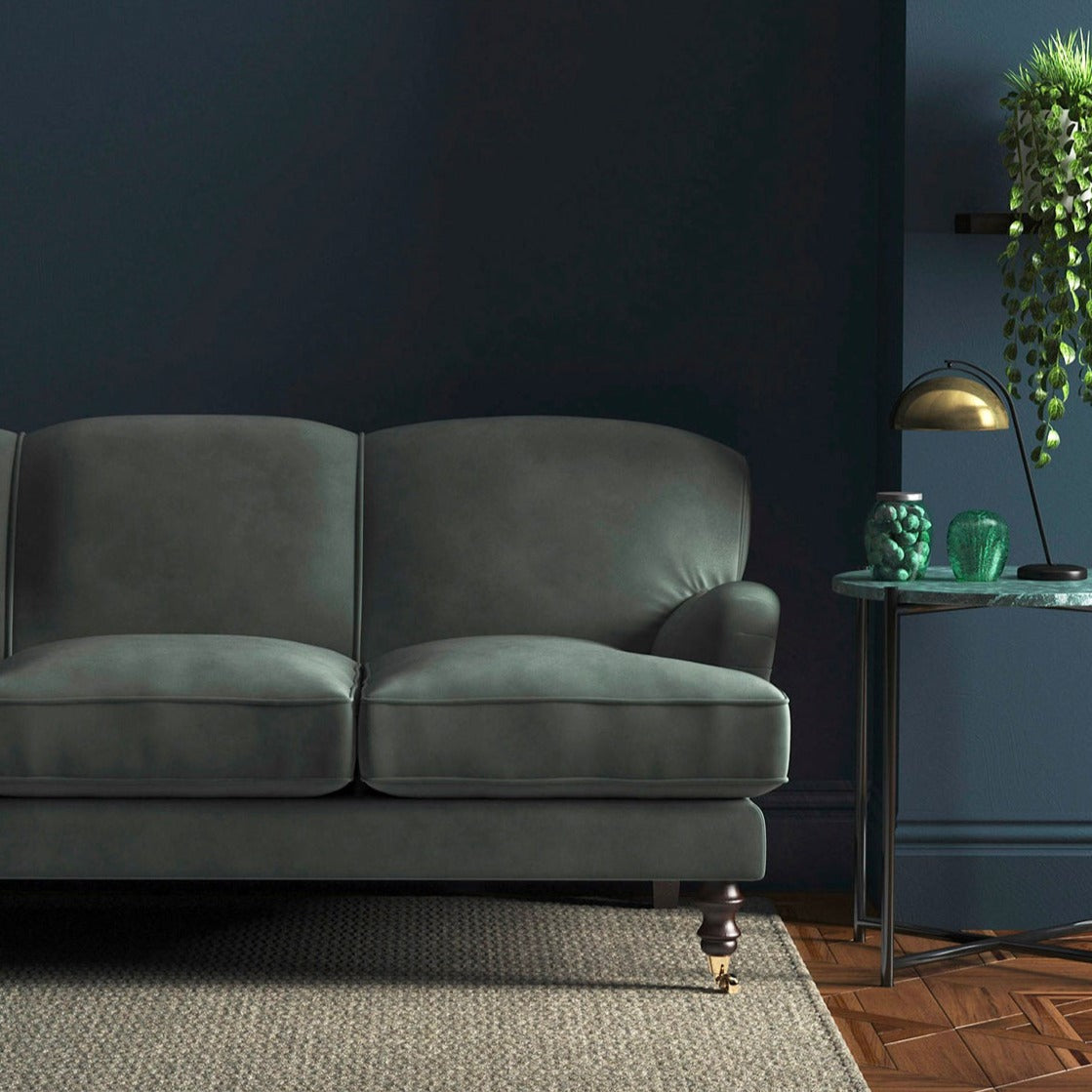 Sofa covered in a blue velvet upholstery fabric