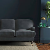 Sofa covered in a grey velvet upholstery fabric