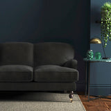 Sofa covered in a grey velvet upholstery fabric