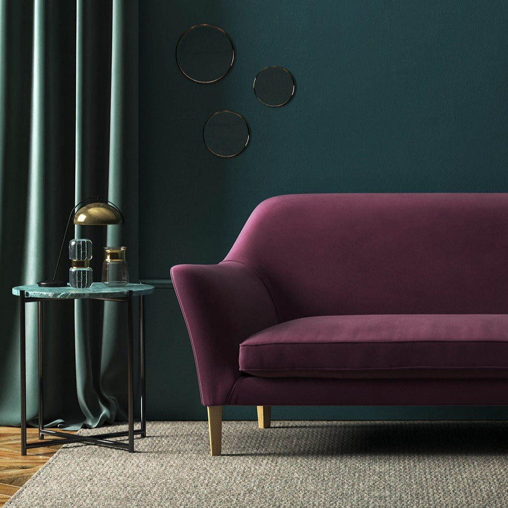 Sofa covered in a purple velvet upholstery fabric 