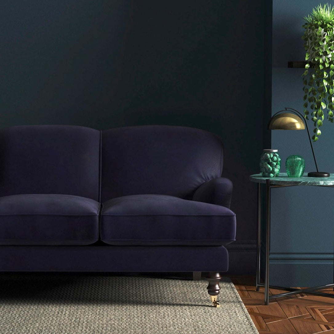 Sofa covered in a purple velvet upholstery fabric