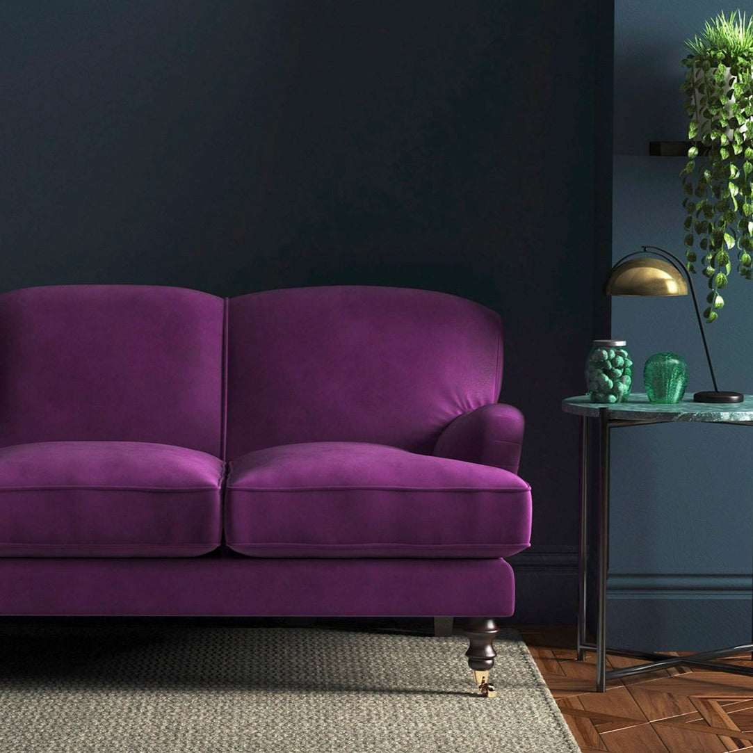 Sofa covered in a purple velvet upholstery fabric