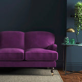 Sofa covered in a purple velvet upholstery fabric