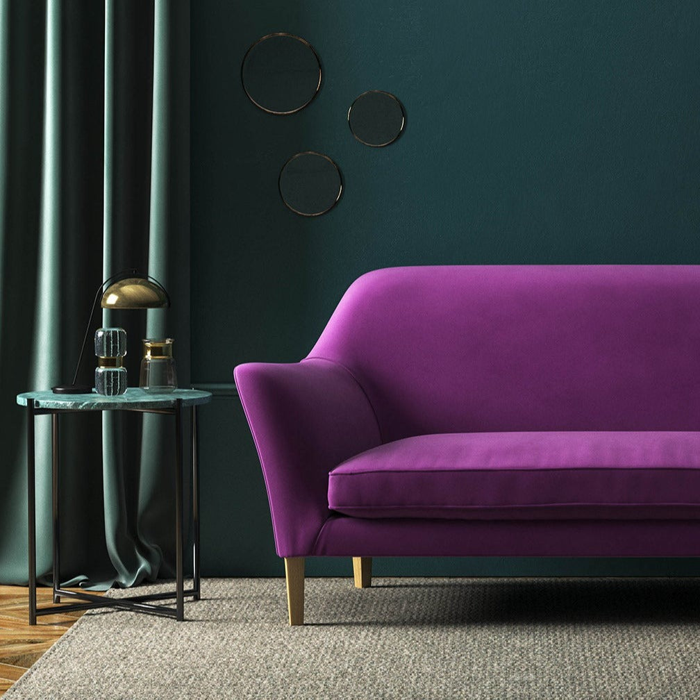 Sofa covered in a purple velvet upholstery fabric 