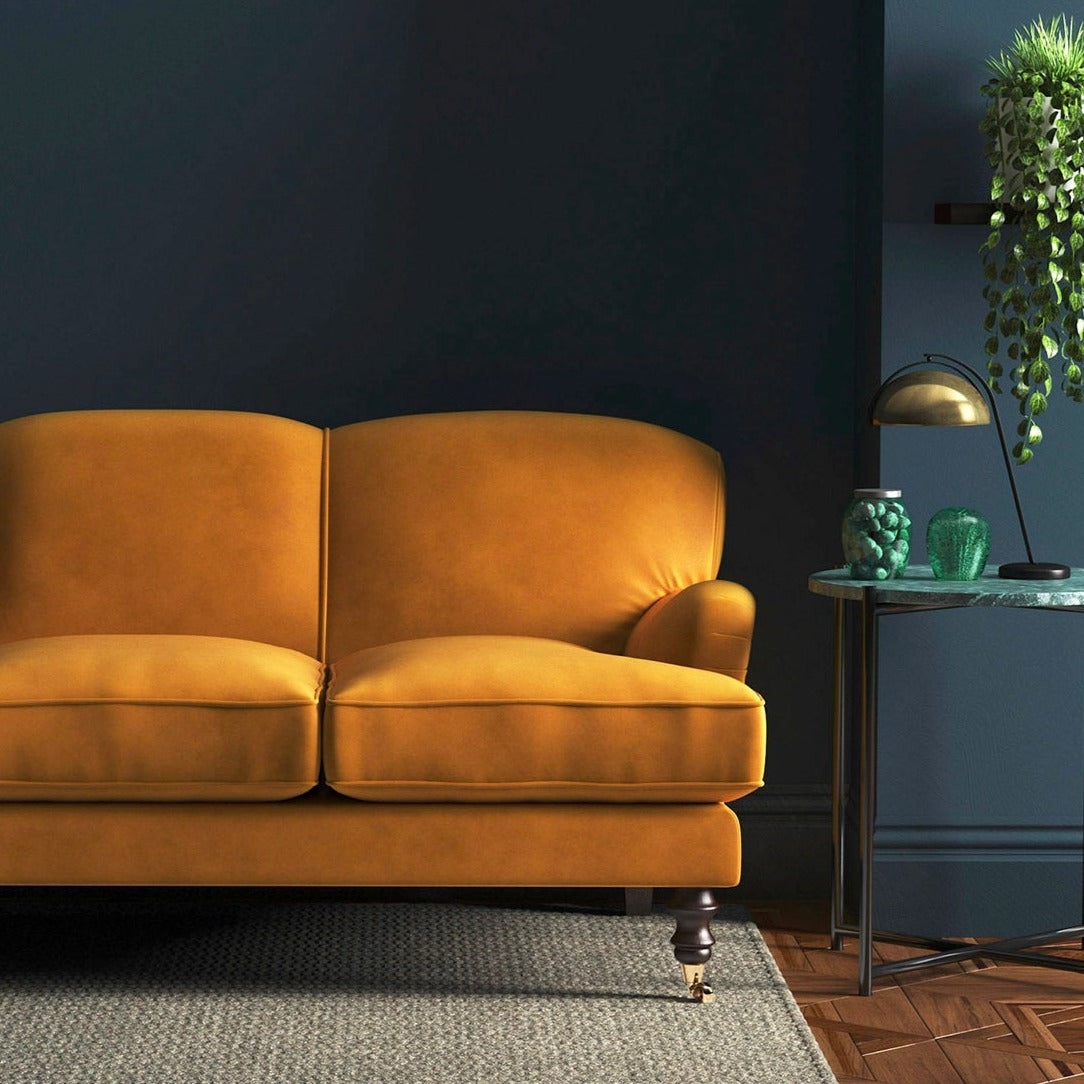 Sofa covered in a orange velvet upholstery fabric