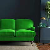 Sofa covered in a green velvet upholstery fabric