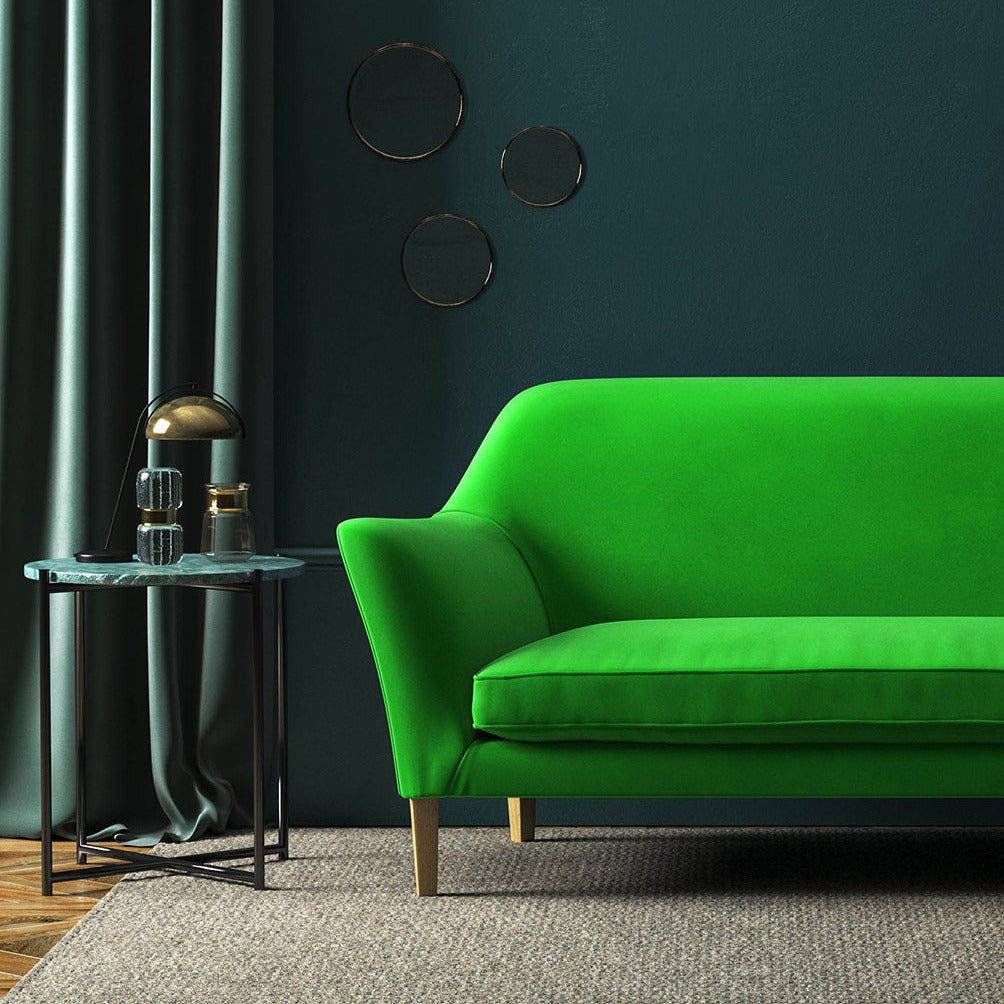 Sofa covered in a green velvet upholstery fabric 