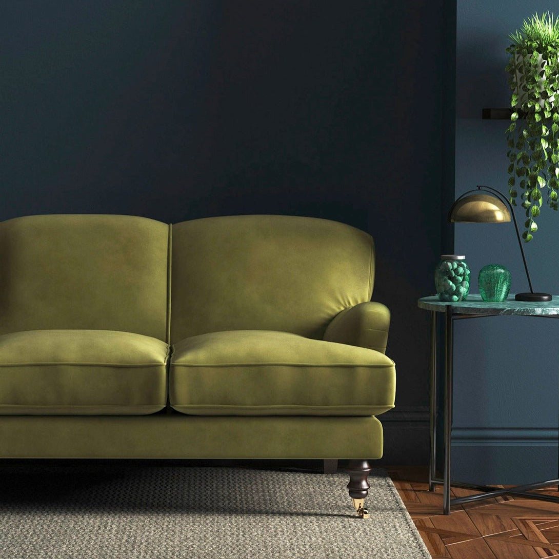 Sofa covered in a green velvet upholstery fabric