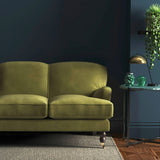 Sofa covered in a green velvet upholstery fabric