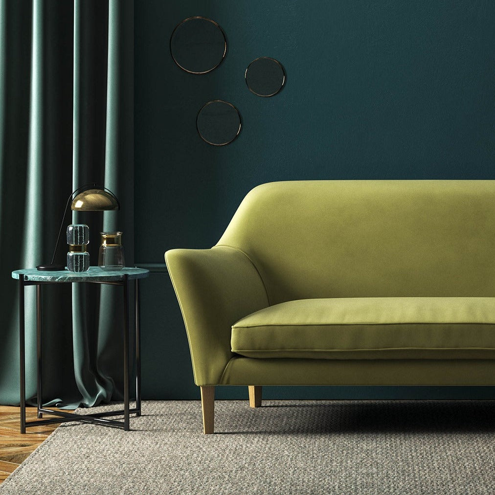 Sofa covered in a green velvet upholstery fabric 