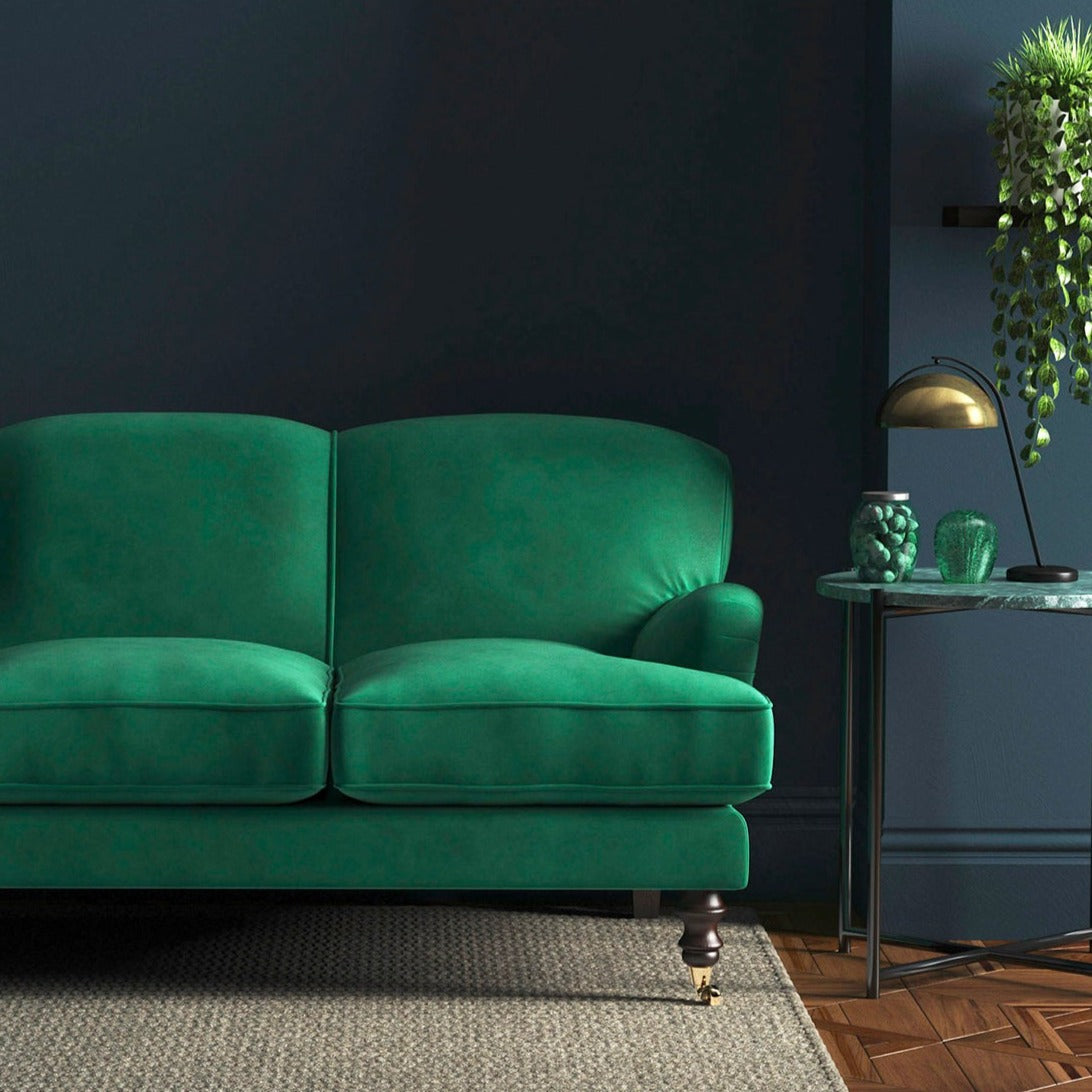 Sofa covered in a green velvet upholstery fabric